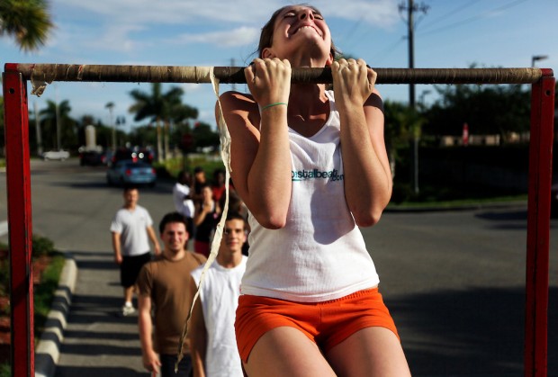 Elaine Neal strains to keep her chin above the bar in a flexed arm hang during a Marine Corps Initial Strength Test at the recruiting sub-station off Pine Ridge Road in Naples on June 3, 2009. The minimum for a female Marine in the flexed arm hang is 15 seconds, but Neal finished with a personal best of 70 seconds. Neal said that for a lot of activities she generally loses interest after time and ends up quitting, but the choice to be in the Marines is different. "That's another reason why I really like [the Marines], because I'm trying my best on something," Neal said. Greg Kahn/Staff